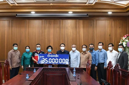 Bí thư, Tỉnh trưởng tỉnh Champasak Vilayvong Butdakham (thứ 5 từ trái qua) nhận ủng hộ của Hội người Việt Nam tỉnh Champasak. (Nguồn: Tổng Lãnh sự quán Pakse)