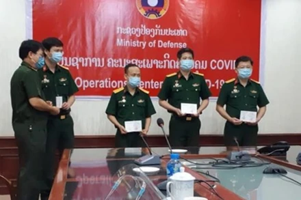 Đại tá Lê Văn Đông (bìa phải) và Đoàn chuyên gia Quân y Việt Nam nhận Huy chương Hữu nghị tại Bộ Quốc phòng Lào, ngày 19-5.