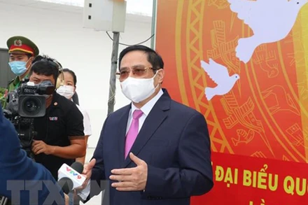 Thủ tướng Phạm Minh Chính gặp gỡ, tiếp xúc báo chí ngay sau khi tham gia bỏ phiếu bầu cử. (Ảnh: Ngọc Thiện/TTXVN).