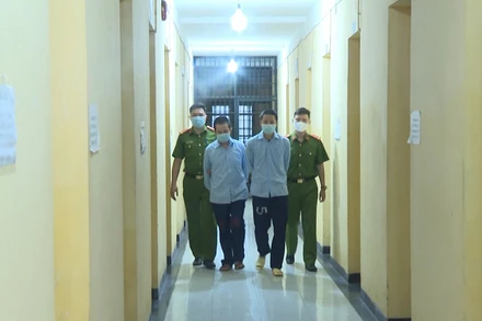 Lực lượng Công an dẫn giải hai đối tượng cầm đầu sàn tiền ảo.