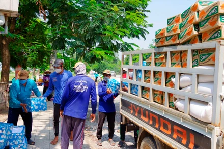 Nhân công đang bốc gạo sang xe của Tổng Hội Việt kiều Campuchia. (Ảnh: Phú Quý)