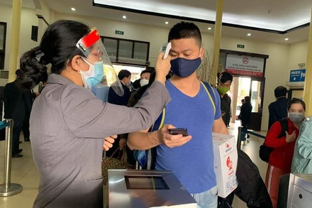 Đo thân nhiệt cho hành khách trước khi lên tàu. (Ảnh: mt.gov.vn)