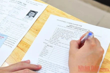 Thí sinh tham dự Kỳ thi tốt nghiệp THPT 2020 điền tờ khai y tế trước khi vào các điểm thi. Ảnh: THUỶ NGUYÊN