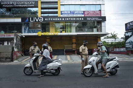 Cảnh sát kiểm tra giấy thông hành của người dân di chuyển tại bang Kerala trong thời gian bang này phong tỏa để kiểm soát dịch bệnh. (Ảnh: AP)