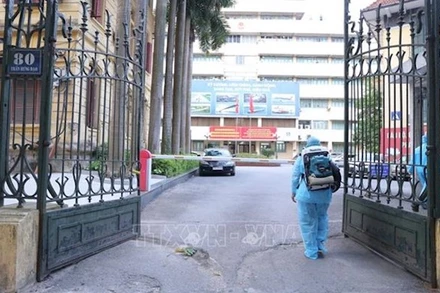 Lực lượng y tế tiến hành phun khử khuẩn tại trụ sở Bộ Giao thông vận tải. (Ảnh: Hoàng Hiếu/TTXVN)