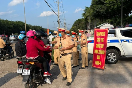 Lực lượng CSGT Công an tỉnh Đồng Nai phát nước suối cho người dân trên Quốc lộ 1A.