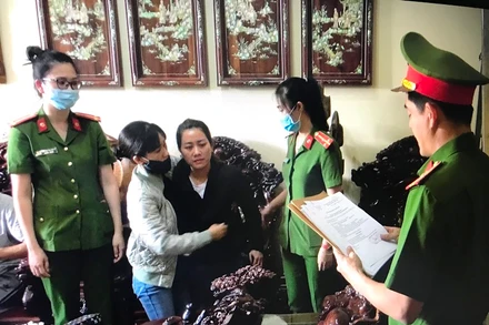 Điều tra viên đọc Lệnh bắt tạm giam với Huyền (áo đen thứ 3 từ trái qua) tại nhà riêng của đối tượng.