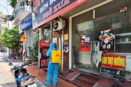Lực lượng chức năng phun thuốc khử khuẩn quán cơm sườn Nam Bộ ở phường Trần Hưng Đạo, TP Hạ Long.