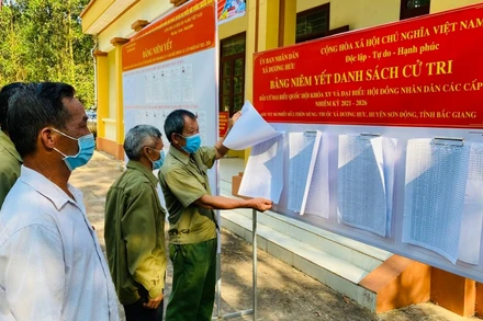 Cử tri thôn Muồng xã Dương Hưu, huyện Sơn Động, Bắc Giang nghiên cứu danh sách cử tri tại điểm niêm yết.