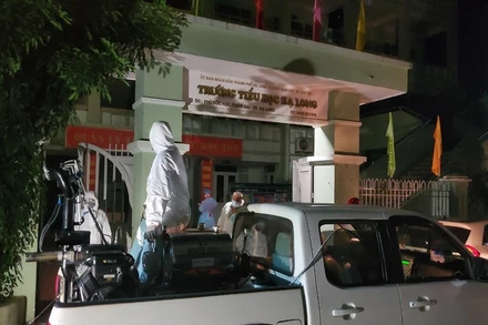 Lực lượng y tế phun thuốc khử khuẩn khu vực liên quan đến ca dương tính với Covid-19 tại Trường tiểu học Hạ Long.