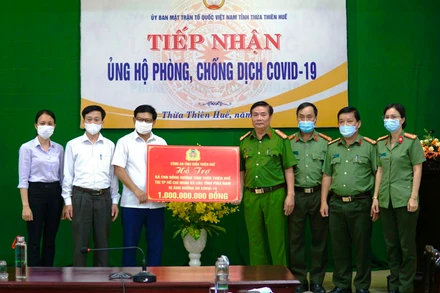 Đại diện lãnh đạo Công an tỉnh trao số tiền 1 tỷ đồng hỗ trợ cho Mặt trận Tổ quốc tỉnh. 