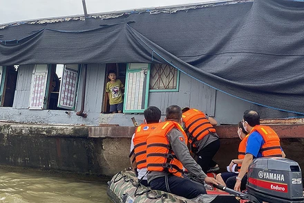 Các thành viên đoàn tình nguyện tiếp cận một gia đình sống trên sông Hồng.