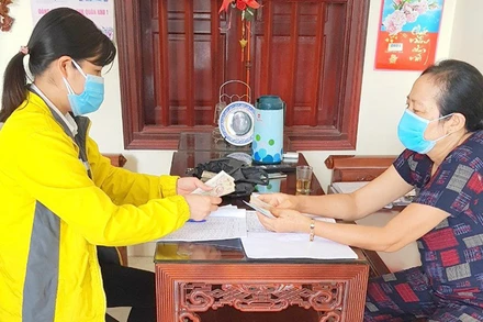 Chi trả lương hưu tại nhà (Ảnh: Bảo hiểm xã hội Hà Nội).