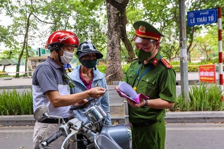 Lực lượng chức năng kiểm tra các phương tiện lưu thông trong thời gian giãn cách xã hội. (Ảnh: TTXVN)