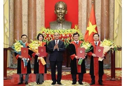 Chủ tịch nước Nguyễn Xuân Phúc trao quyết định và tặng hoa chúc mừng 4 thẩm phán Tòa án Nhân dân tối cao. (Ảnh: TTXVN) 