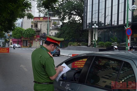 Lực lượng chức năng kiểm tra giấy đi đường của người dân tại lưu thông trên tuyến đường Thanh Niên (Hà Nội). Ảnh: Minh Hà
