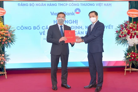 Ủy viên Dự khuyết Trung ương Đảng Nguyễn Long Hải trao quyết định và tặng hoa chúc mừng đồng chí Trần Minh Bình.