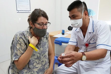 Nhân viên y tế cung cấp thông tin vaccine cho một cán bộ của tổ chức Phi chính phủ nước ngoài tại buổi tiêm ngày 13/7 (Ảnh: BV Phổi T.Ư). 