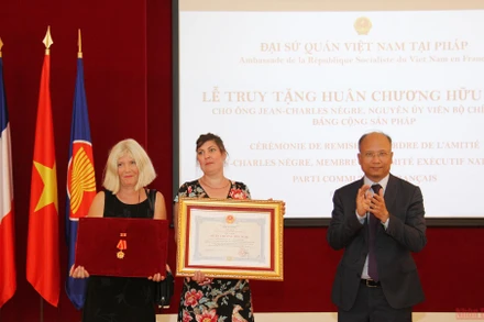 Đại sứ Đinh Toàn Thắng trao tặng Huân chương Hữu nghị cho vợ và con gái đồng chí Jean-Charles Nègre. (Ảnh: KHẢI HOÀN - ĐÌNH TUẤN).