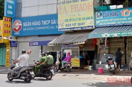 Lực lượng chức năng đi qua các cửa hàng đang kinh doanh nhưng không nhắc nhở. (Ảnh chụp trên đường Nơ Trang Long, quận Bình Thạnh)