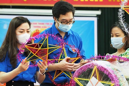 Các tình nguyện viên làm đèn ông sao tặng các em thiếu nhi tại Trung tâm Nuôi dưỡng người già và trẻ tàn tật Hà Nội.