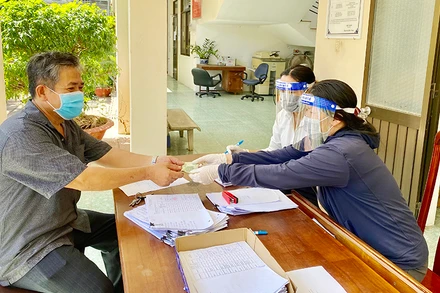 Người dân phường 2, TP Vũng Tàu (tỉnh Bà Rịa - Vũng Tàu) nhận tiền hỗ trợ theo Nghị quyết 68 của Chính phủ. Ảnh: LINH ÐAN