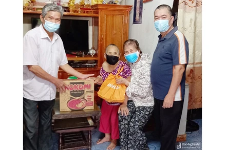 Cán bộ khối 5, thị trấn Cầu Giát, huyện Quỳnh Lưu, trao hỗ trợ nhu yếu phẩm cho người dân.