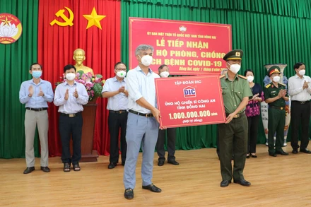 Lãnh đạo Công an tỉnh Đồng Nai tiếp nhận số tiền 1 tỷ đồng từ Tổng Công ty cổ phần Đầu tư và Phát triển Xây dựng DIC. (Ảnh: THIÊN VƯƠNG/BND). 