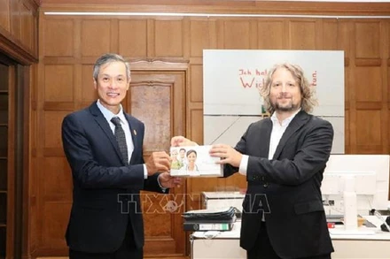 Ngày 19/8 tại Berlin, chính quyền thành phố này đã trao tặng Việt Nam 30.000 bộ kit xét nghiệm nhanh Covid-19. Trong ảnh: Ông Christian Rickerts - Quốc vụ khanh Bộ Kinh tế bang Berlin (phải), đại diện cho chính quyền thủ đô Berlin trao tặng kit xét nghiệm cho Đại sứ Nguyễn Minh Vũ. (Ảnh: TTXVN).