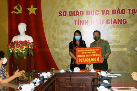 Lãnh đạo Công an tỉnh Hậu Giang trao bảng tượng trưng cho Sở Giáo dục và Đào tạo.