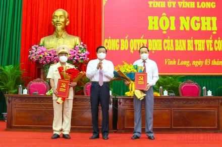 Bí thư Tỉnh ủy Vĩnh Long tặng hoa chúc mừng tân Phó Bí thư Tỉnh ủy Vĩnh Long Nguyễn Thành Thế (phải) và Đại tá Nguyễn Trọng Dũng, Giám đốc Công an tỉnh Vĩnh Long. (Ảnh: Bá Dũng)