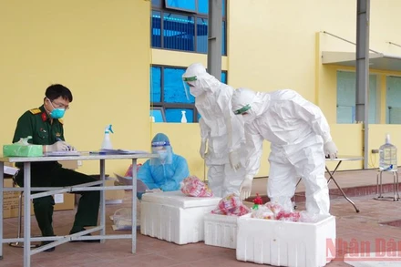 Đoàn công tác của quân đội tiếp nhận mẫu xét nghiệm sàng lọc SARS-CoV-2 tại nơi xét nghiệm lưu động.