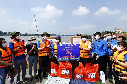 Đại diện các đơn vị, nhà tài trợ bàn giao máy tính/máy tính bảng để vận chuyển đến trao tận tay thiếu nhi ở làng chài ven sông Hồng.