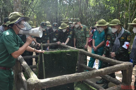 Du khách tham quan một hầm chông với nắp tự động của người dân Củ Chi. 