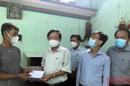 Bí thư Huyện ủy Bình Sơn (Quảng Ngãi) Lương Kim Sơn trao tiền hỗ trợ cho gia đình có nhà bị hư hỏng do lốc xoáy.