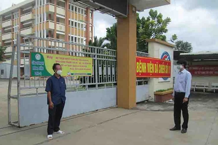 Thầy Đàm Văn Tuyến, Hiệu trưởng trường THPT chuyên Long An (phải) thăm trường trong mùa dịch trước ngày khai giảng năm học mới và trò chuyện với Phó giám đốc Bệnh viện dã chiến số 11 đặt ngay tại trường. 