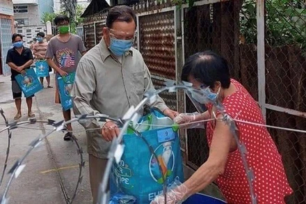 Người dân ở quận 12 nhận nhu yếu phẩm hỗ trợ của chính quyền địa phương.