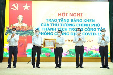 Chủ tịch UBND TP Hà Nội Chu Ngọc Anh trao Bằng khen của Thủ tướng Chính phủ cho nhân dân và cán bộ huyện Đông Anh về thành tích trong công tác phòng, chống dịch Covid-19.