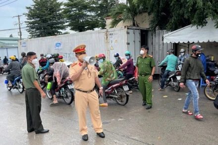 Lực lượng chức năng tỉnh Đồng Nai phát loa vận động người dân quay trở về nơi ở cũ.