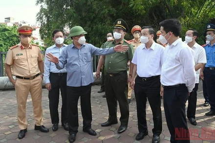 Bí thư Thành ủy Đinh Tiến Dũng cùng đoàn công tác kiểm tra tại chốt Cầu Diễn trên tuyến Quốc lộ 32. (Ảnh: DUY LINH)