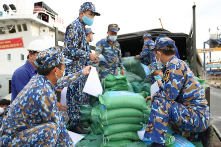 Các cán bộ, chiến sĩ Hải quân chuẩn bị kỹ từng bao gạo nhỏ trước khi chuyển đến người dân.