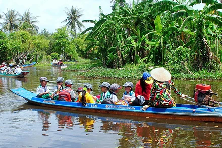 Học sinh tiểu học vùng sâu của huyện Trần Văn Thời, tỉnh Cà Mau đến trường trong năm học mới (Ảnh tư liệu năm 2018). 