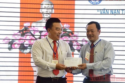 Chủ tịch Hội Nhà báo tỉnh Khánh Hòa Đoàn Minh Long (trái) trao khoản tiền 10 triệu đồng do Hội thảo quyên góp cứu trợ đồng bào miền trung bị bão lụt.