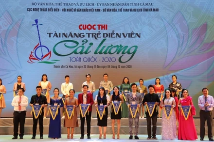 Đại diện Ban Tổ chức trao cờ lưu niệm cho những thí sinh dự thi. (Ảnh: Cục NTBD)