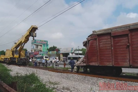 Các lực lượng chức năng khẩn trương khắc phục sự cố hai toa tàu bị lật do tàu bị trật bánh.