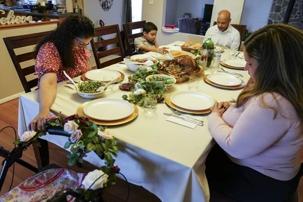 Một gia đình tại TP New York, Mỹ, cầu nguyện trước bữa ăn trong Lễ Tạ ơn, ngày 26-11. (Ảnh: AP)