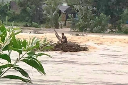 Ông Nguyễn Văn Tự đang mắc kẹt giữa dòng nước chờ cứu hộ. 