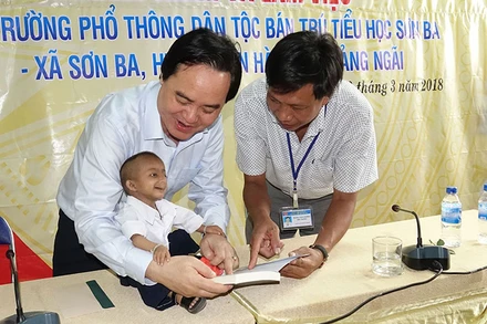 Bộ trưởng Phùng Xuân Nhạ cùng thầy giáo Đặng Văn Cương và em Đinh Văn K'Rể. (Ảnh: HIỂN CỪ)