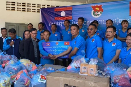 Ông Giang Công Huân (phải) tại buổi lễ trao ủng hộ các gia đình khó khăn tại xã Namka, huyện Phaxay, tỉnh Xiengkhuang. (Ảnh: Hội Thanh niên Việt Nam tỉnh Xiengkhuang)