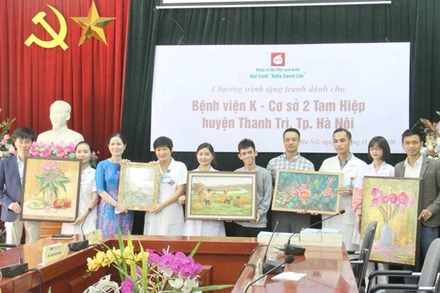 Họa sĩ Nguyễn Thị Kim Đức (thứ ba từ trái sang) trao tặng bộ tranh cho Bệnh viện K cơ sở 2. (Ảnh: Nguyễn Hoàng)